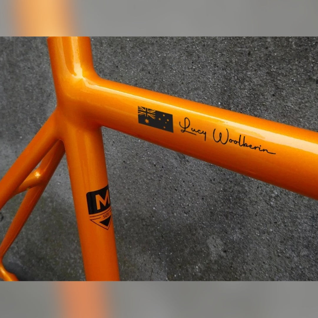 Bike name decal – black Australian flag and black script name Lucy Woolberin on an orange bike frame tube