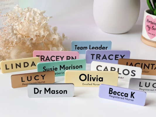 Collection of name tags with various names on a white surface.