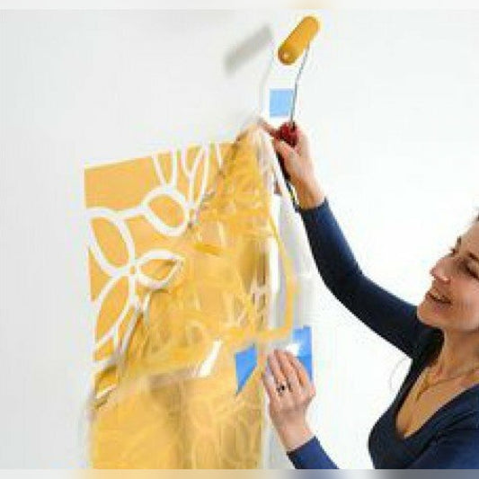 Custom vinyl stencil decal – peeling the stencil off a wall after rolling on a yellow floral pattern
