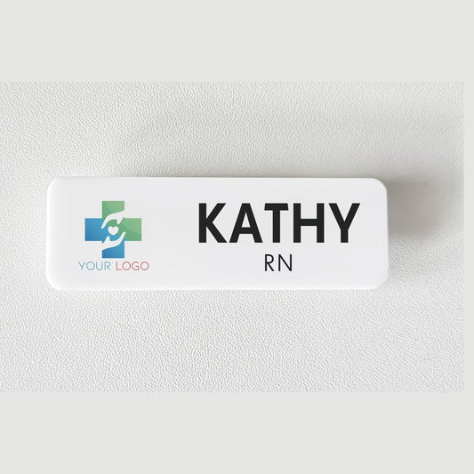 Acrylic name badge – white badge with a placeholder cross-and-hands logo and the name KATHY with RN below