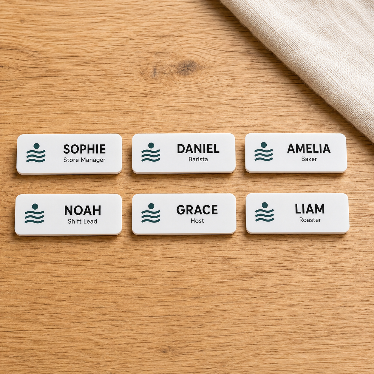 Six matching team name badges on a timber table