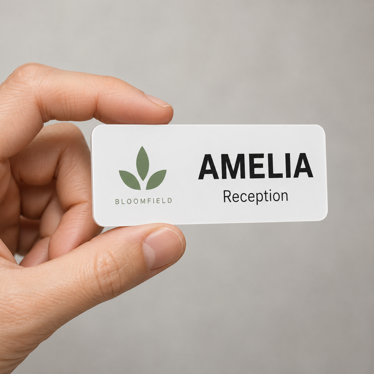 Name badge held in hand to show its size