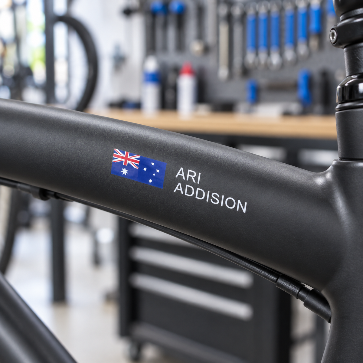 Clear print Australian flag name sticker on a matte black road bike top tube