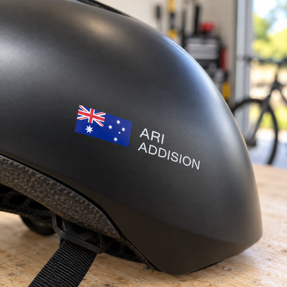 Clear print Australian flag name sticker on a black cycling helmet