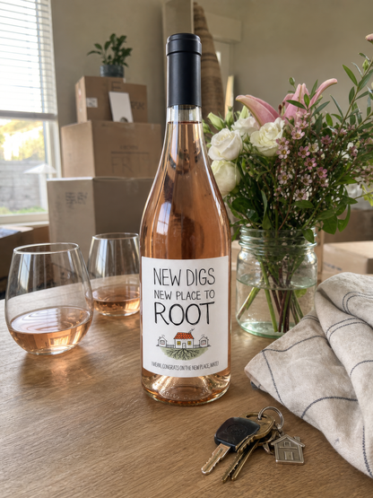 New Digs wine label in colour – bottle beside moving boxes, flowers and house keys