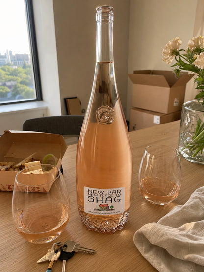 New Pad wine label in colour – rosé bottle on a table with glasses, flowers and moving boxes