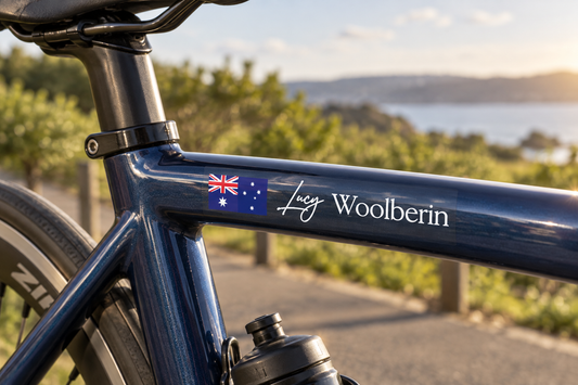 Option 1 signature-style flag and name sticker on a blue bicycle top tube