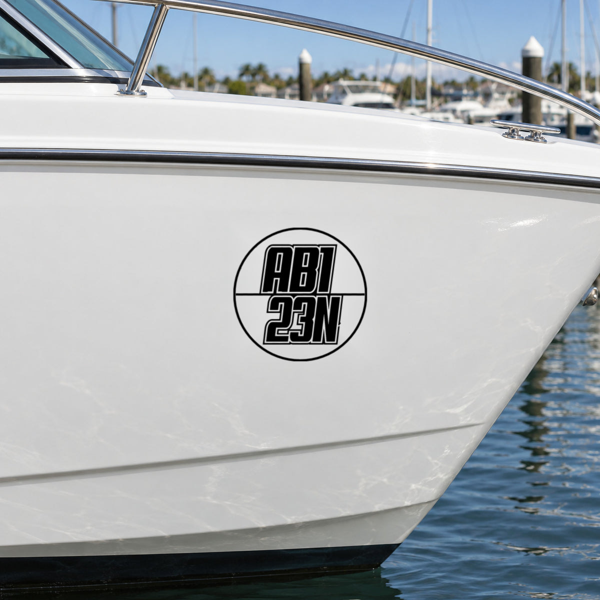 Black round boat rego decal with italic outlined numbers on a white boat hull